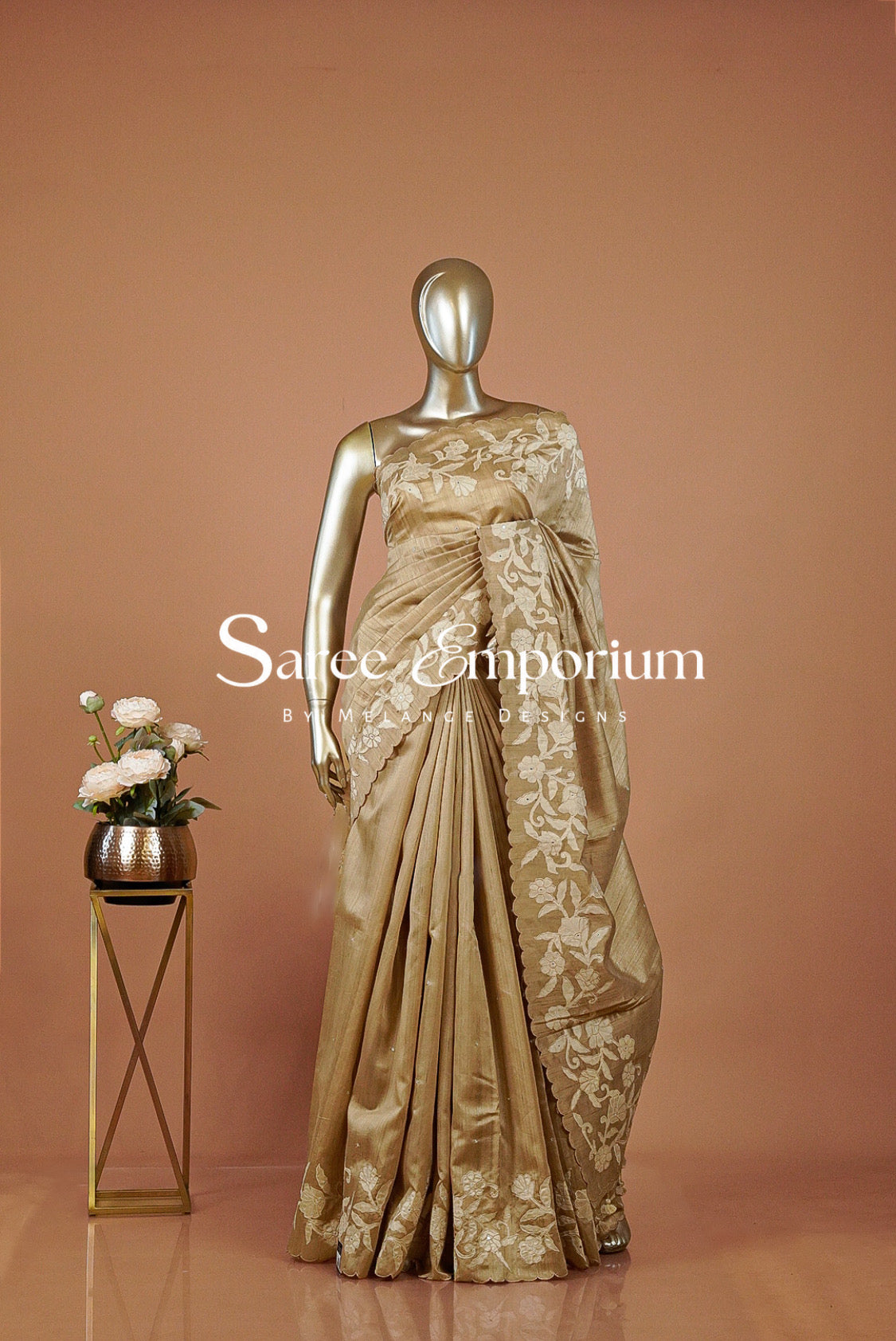 A metallic gold saree with intricate floral embroidery .