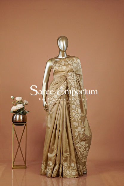 A metallic gold saree with intricate floral embroidery .