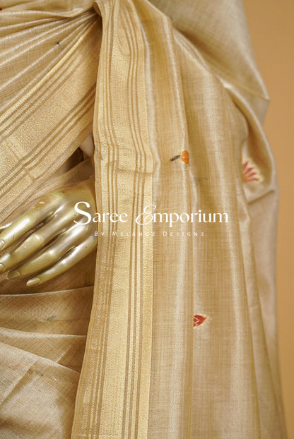 Champagne-Gold silk saree with vertical pleats and a border, featuring small red and orange embroidered motifs. 