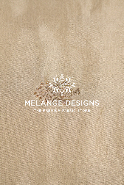 A close-up of a beige Tissue Satin Embroidery Fabric Dyeable surface .