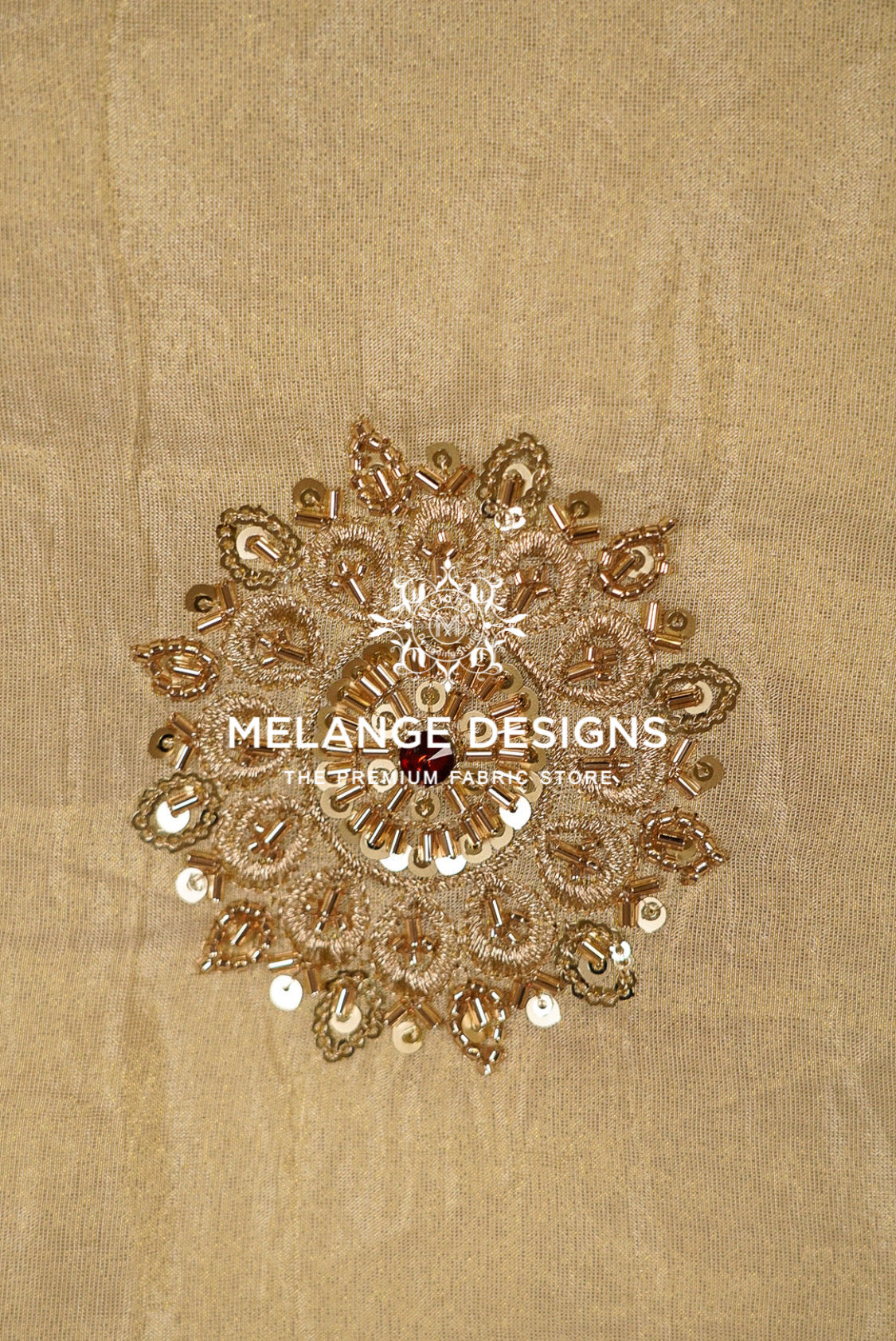 A circular, ornate gold sequin and bead embellishment with metallic gold embroidery, displayed on a textured beige Tissue Silk Embroidery Fabric .